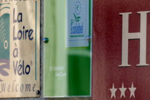 plaques d'information sur la façade de l'hotel la Tonnellerie affichant 3 étoiles et la label ecolabel européen